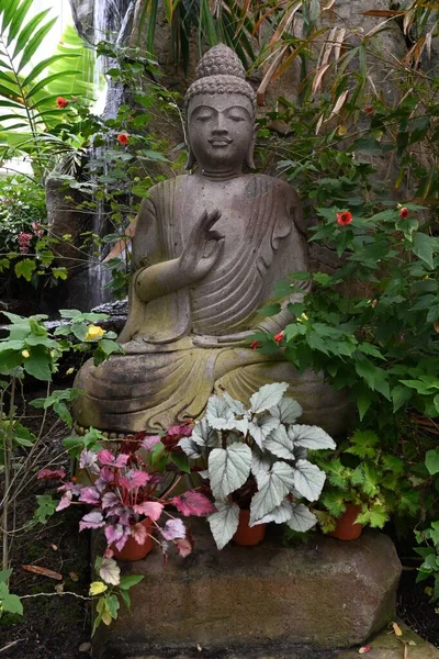 Вертикальный Снимок Статуи Будды Саду Красивыми Цветами — стоковое фото