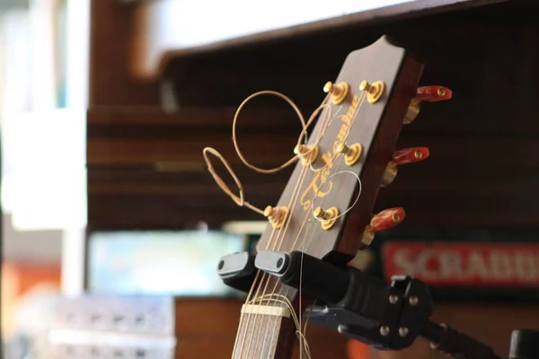 A closeup shot of a guitar handle with broken strings