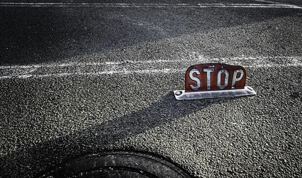Крупный план красного знака "Стоп" посреди дороги в дневное время — стоковое фото