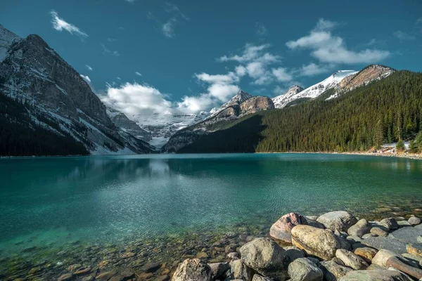 曇り空の下の冷たい湖に反射する山々の美しいショット — ストック写真