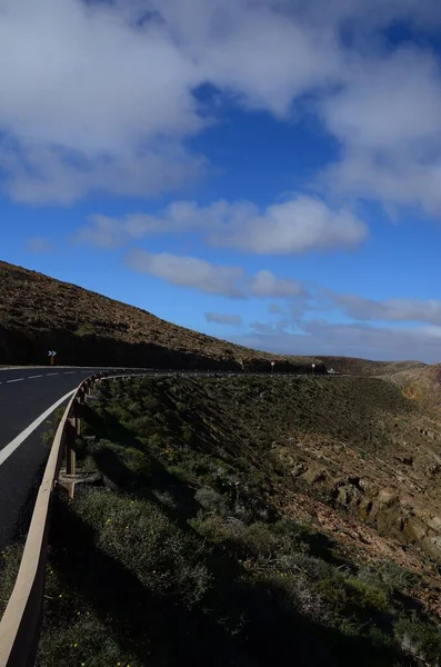 Vertical tiro uma estrada nas colinas de Fuerteventura Ilhas Canárias sob o céu nublado brilhante — Fotografia de Stock