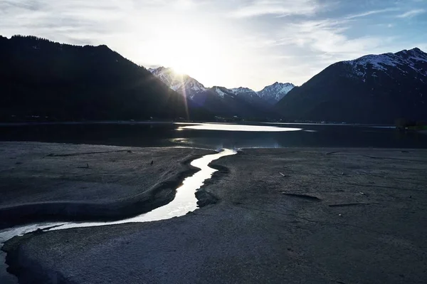 Belo tiro de um lago com o reflexo do céu e uma rachadura na costa — Fotografia de Stock