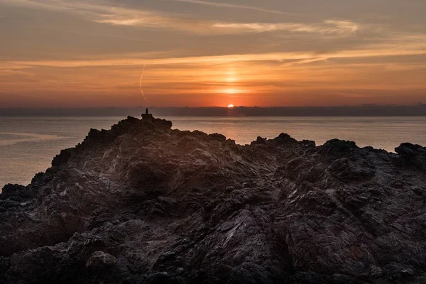 Rocky land with the ocean and the sunset in the background — Stock Photo, Image