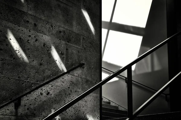 Escala de grises de la barandilla de una escalera junto a un muro de piedra - concepto futuro desconocido — Foto de Stock