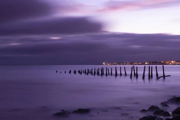 Hermoso Disparo Puente Roto Sobre Mar Con Nubes Púrpuras Fondo —  Fotos de Stock