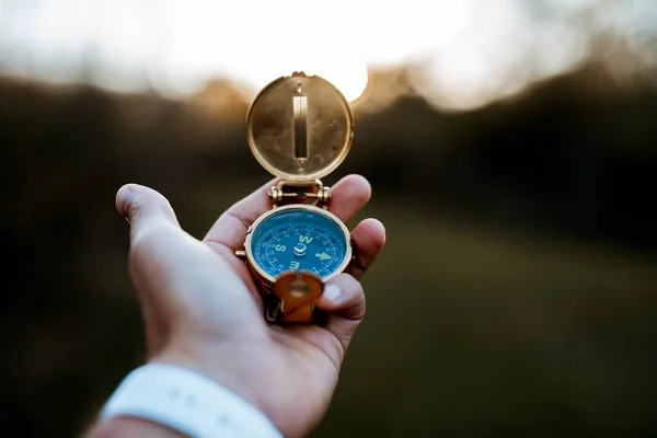 Closeup shot of a person holding a compass with a blurred background — Stock Photo, Image