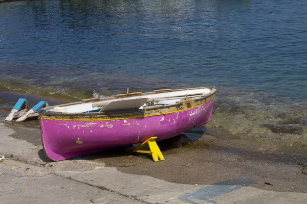 Tiro de un bote skiff rosa estacionado en la orilla del mar en un hermoso día de primavera — Foto de Stock