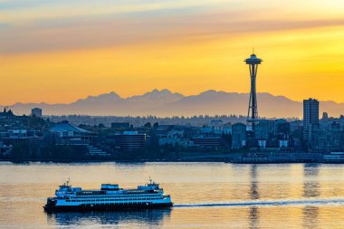 Ferry on the water with the city of Seattle, USA under the beautiful sunset in the background clipart