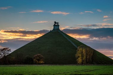 Lion's Mound on a high grassy hill in Belgium under the breathtaking sky clipart