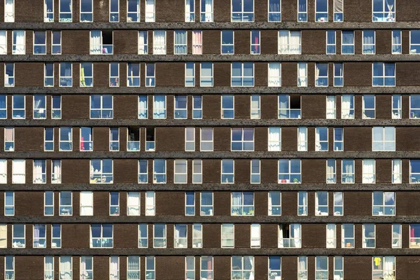 Schönes, neutrales braunes Mehrfamilienhaus mit Glasfenstern, in dem verschiedene Familien leben — Stockfoto