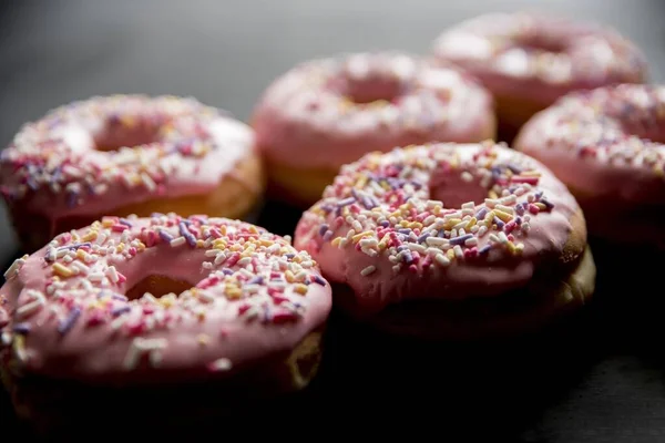 Nahaufnahme von rosa Donuts mit Funkeln vor verschwommenem Hintergrund — Stockfoto
