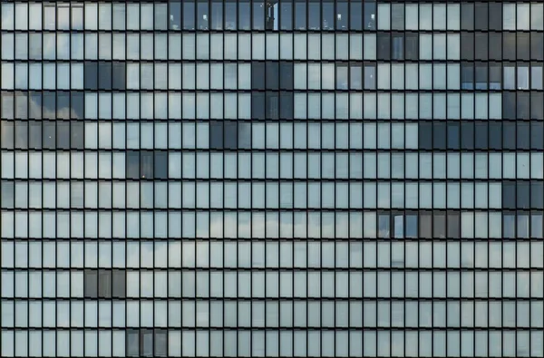 Immeuble moderne avec fenêtres vitrées témoignant silencieusement de la vie de la grande ville — Photo