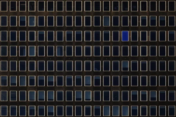Neutral black building with blue windows hiding everything that goes on behind walls — ストック写真