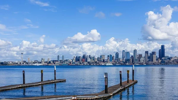 Wooden pier over a sea with the city of Seattle, USA under the beautiful clouds in the background — Stockfoto