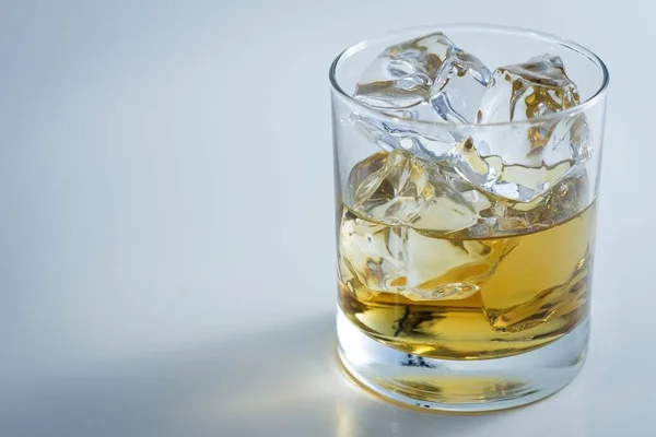 Gros plan d'un verre rempli de glace et de whisky isolé sur un fond blanc — Photo