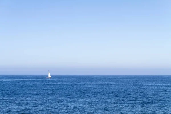 शांत सुंदर महासागराच्या क्षैतिजमध्ये व्हाइट बोट फ्लोटिंग — स्टॉक फोटो, इमेज