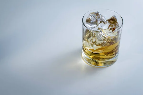 Hochwinkelaufnahme eines Glases voll Eis und etwas Whisky isoliert auf weißem Hintergrund — Stockfoto