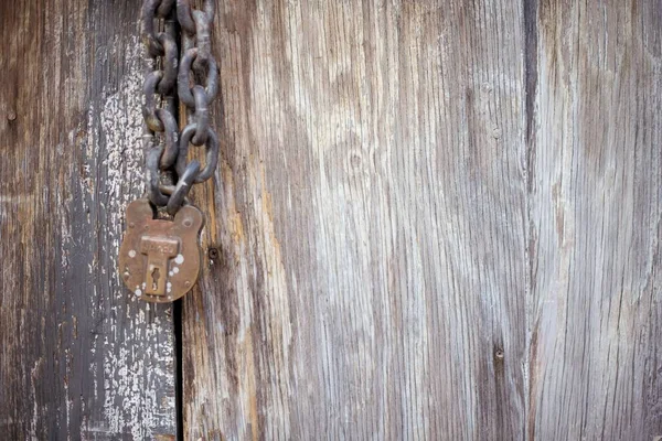 Belle vue rapprochée d'une vieille porte en bois avec une serrure en fer rouille et des chaînes — Photo