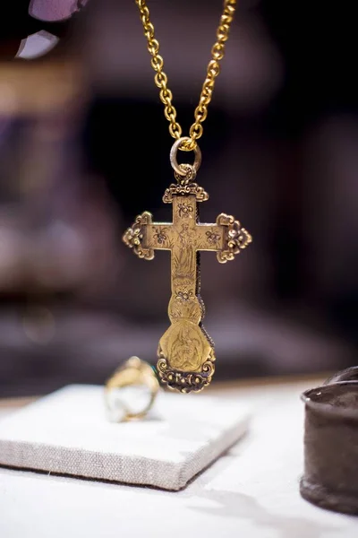 Zdjęcia z bliska wielkiego, złotego krzyża chrześcijańskiego z przedstawionymi ikonami na rozmytym tle — Zdjęcie stockowe