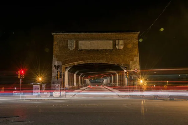 Včasný záběr světel aut na silnici poblíž tunelu v noci v Pavia, Itálie — Stock fotografie