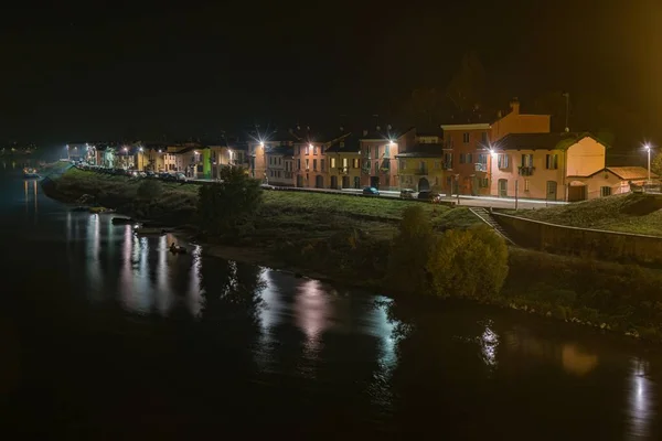 意大利帕维亚夜晚湖中反射灯光的漂亮的公寓楼照片 — 图库照片