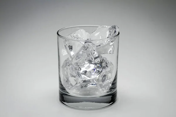 Primer plano de escamas grises de un vaso lleno de cubitos de hielo aislados sobre un fondo blanco —  Fotos de Stock