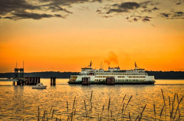 Grande nave sull'acqua vicino a un molo con il bellissimo tramonto nel cielo sullo sfondo — Foto Stock