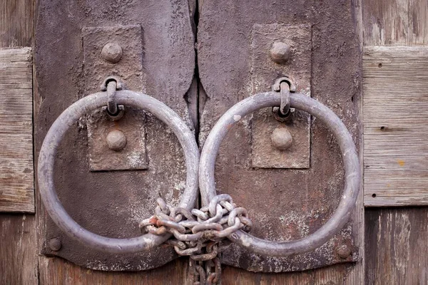 Zincirle sarılı iki pas çemberinden yapılmış bir kilidi olan tahta kapı. — Stok fotoğraf