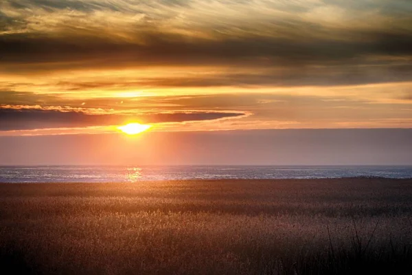 Magnifique coucher de soleil sur la plage créant le décor parfait pour les promenades en soirée sur la rive — Photo