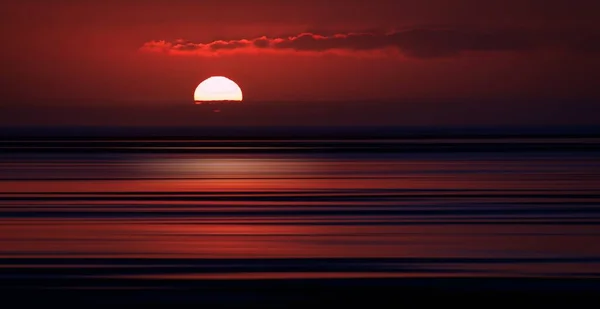 Belo pôr do sol com cores únicas na praia, criando o cenário perfeito para caminhadas noturnas — Fotografia de Stock