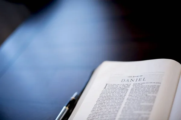 Primer plano de una Biblia abierta cerca de una pluma estilográfica con un fondo borroso —  Fotos de Stock