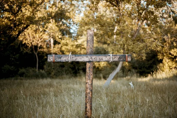 Detailní záběr dřevěného kříže v trávě s rozmazaným pozadím — Stock fotografie