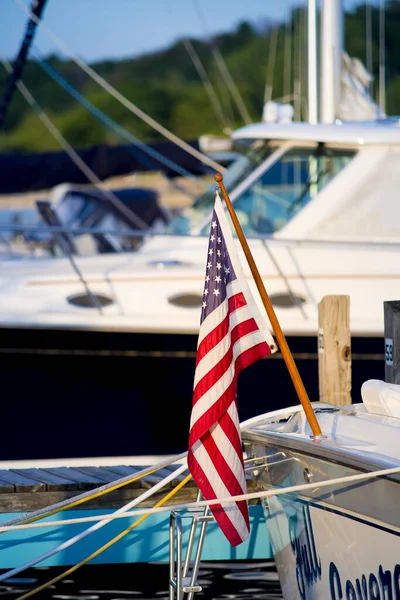 Foto de close-up vertical da bandeira dos Estados Unidos pendurada em um barco com um fundo embaçado — Fotografia de Stock