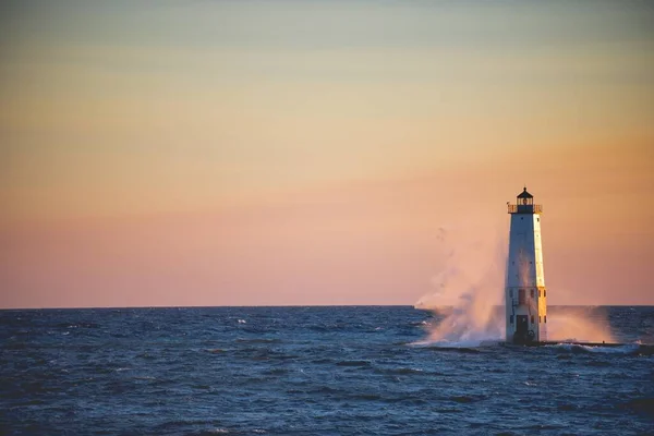 Schöne Aufnahme eines Leuchtturms mitten im Meer mit rosa Himmel im Hintergrund — Stockfoto