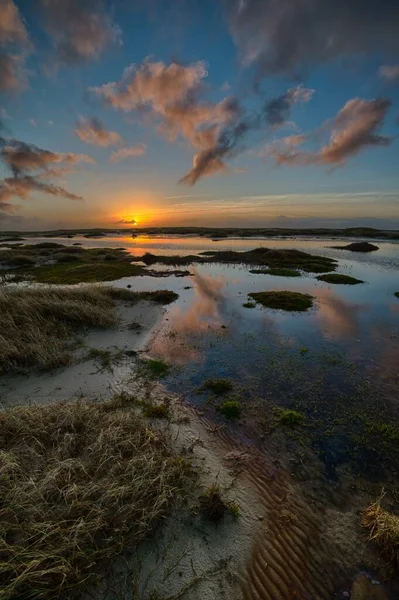 Vertical shot of a beautiful sunset at the beach creating the perfect scenery for evening walks — Stock Photo, Image