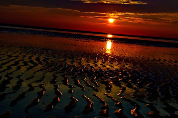 Häpnadsväckande solnedgång skapar den perfekta atmosfären av nattvandringar på stranden — Stockfoto
