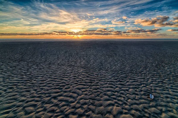 Beautiful sunset at the beach creating the perfect scenery for evening walks at the shore — Stock Photo, Image