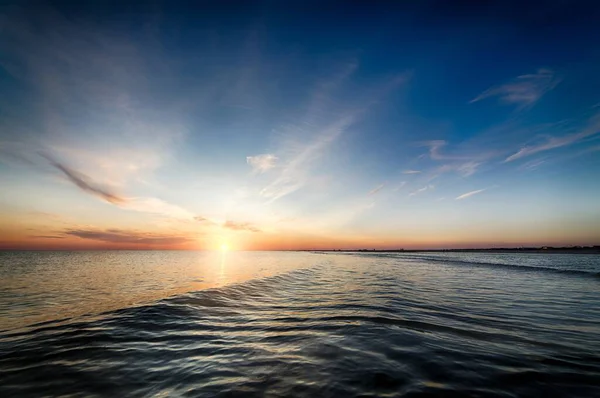 Bellissimo tramonto in spiaggia creando il paesaggio perfetto per passeggiate serali sulla riva — Foto Stock