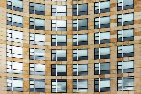 Niski kąt ujęcia nowoczesnego brązowego budynku z kreatywnie ukształtowanymi oknami — Zdjęcie stockowe