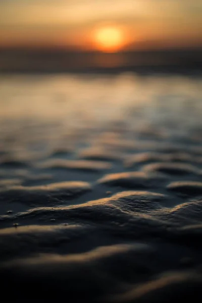 Mise au point sélective verticale de sable mouillé au coucher du soleil — Photo