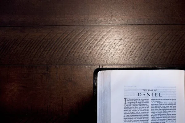 Overhead closeup shot of an open Bible with a wood surface in the background — Stok Foto