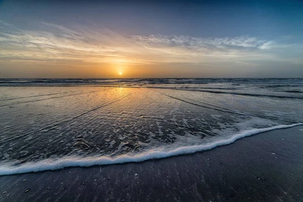 Hermoso atardecer en la playa creando el escenario perfecto para paseos nocturnos en la orilla — Foto de Stock