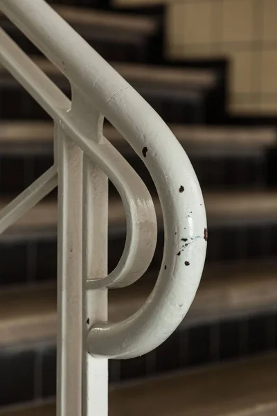 Vertical close-up tiro de um corrimão branco e as escadas embaçadas no fundo — Fotografia de Stock