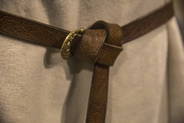 Gros plan d'une ceinture en cuir attachée sur un vêtement blanc — Photo