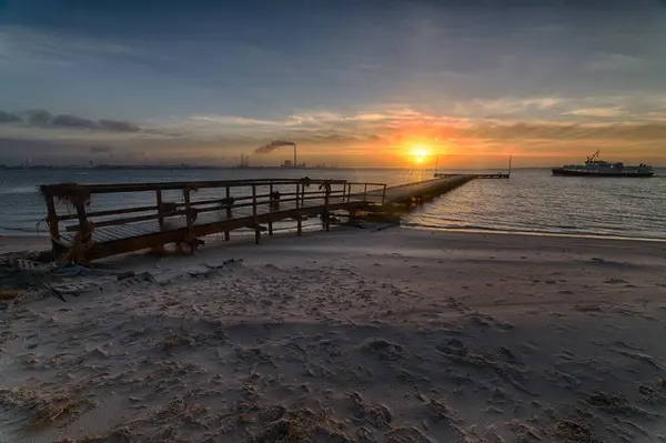 Belo pôr do sol sobre o cais na praia, criando o cenário perfeito para caminhadas noturnas — Fotografia de Stock