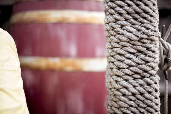 Close-up tiro de uma corda enrolado em torno de um pólo com um barril borrado no fundo — Fotografia de Stock