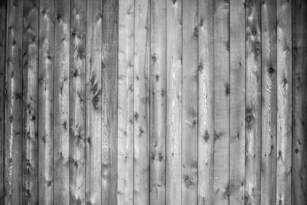 Grayscale shot van een muur gemaakt van verticale houten planken - perfect voor een koele achtergrond — Stockfoto