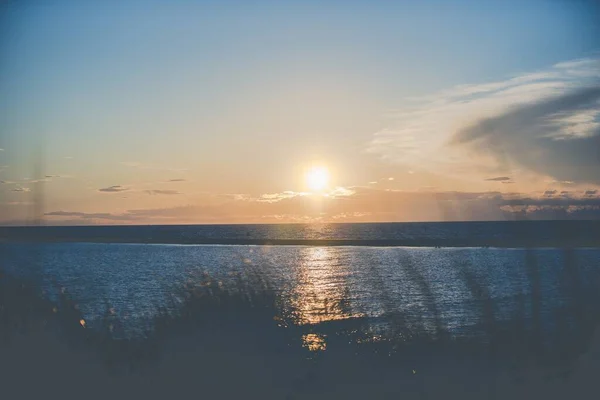 Bellissimo scatto di un mare vuoto con il sole splendente in un cielo blu sullo sfondo — Foto Stock