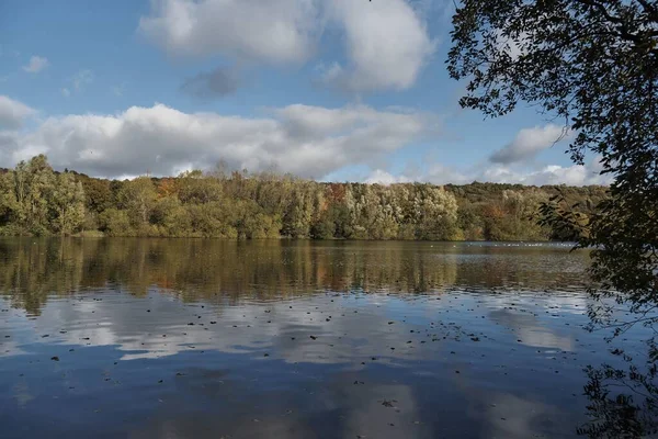 Prachtige opname van een meer met de weerspiegeling van de bomen en de wolken van de lucht — Stockfoto