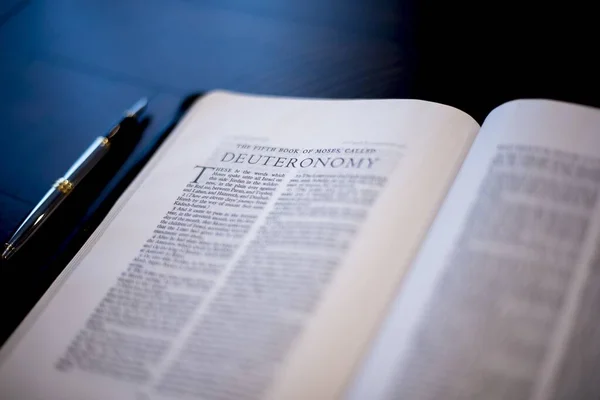 Gros plan de la bible sacrée près d'un stylo plume sur la table avec un fond flou — Photo